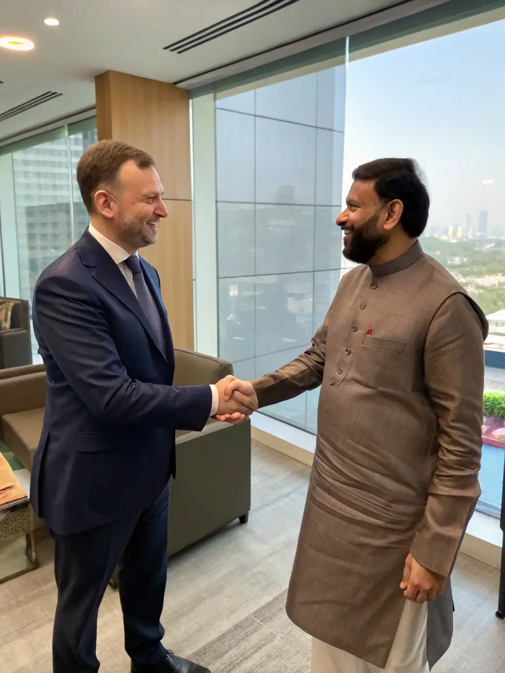 A successful Indian SME owner shaking hands with a Successpeak coach, symbolizing partnership and achievement.