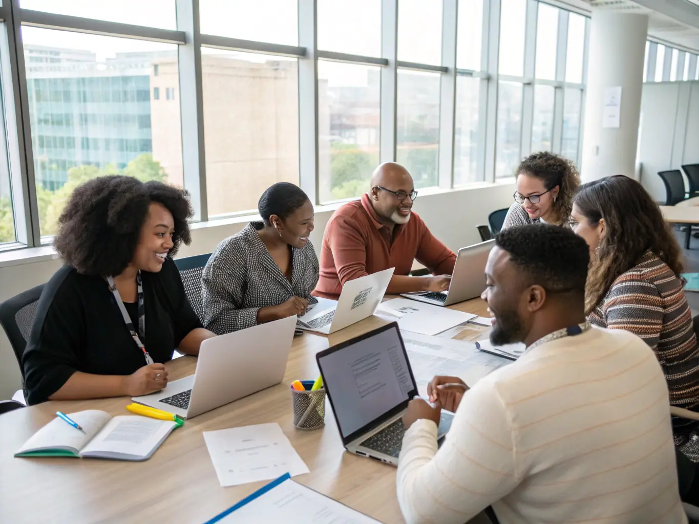 A diverse team of Indian SME employees collaboratively brainstorming ideas around a table in a modern office setting, symbolizing team building and innovation.